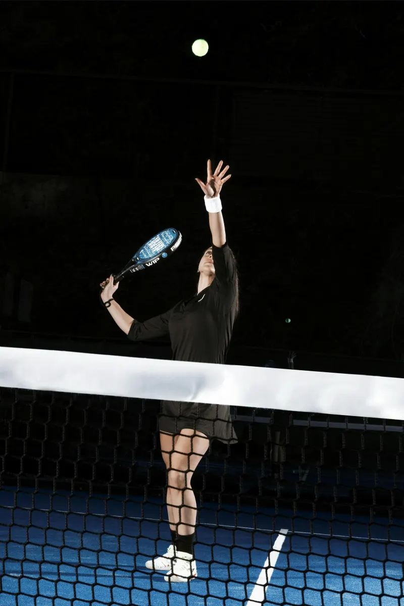 Padel player reaching up for a smash at the net